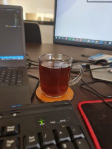 View larger photo: Black tea is in between the laptop, the external keyboard, and the monitor. 