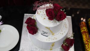 View larger photo: An anniversary cake in white adorned with red roses.