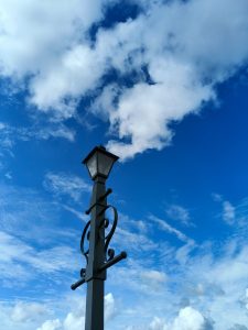 Vintage lamp and cloudy skies,lamp looks like chimney and clouds be like the smoke coming from chimney.